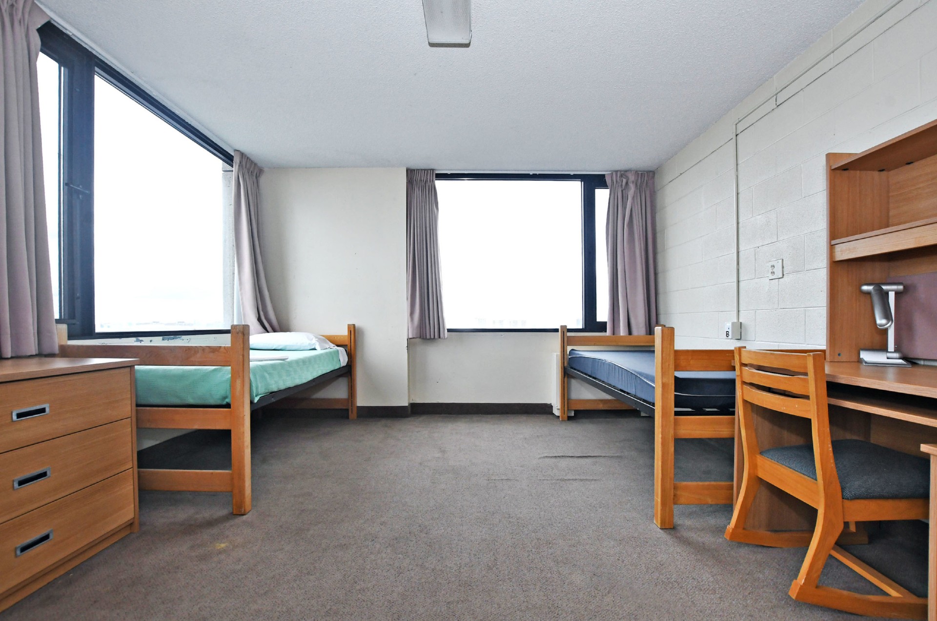 Picture of a double room in Bethune building. Two windows, two beds, a desk and a dresser.
